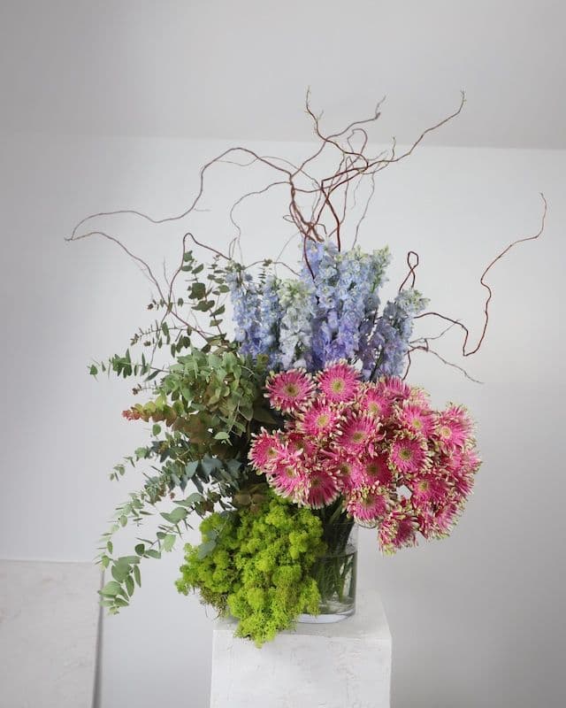 Composition florale moderne et excentrique avec gerberas Pasta roses, delphinium bleu, eucalyptus