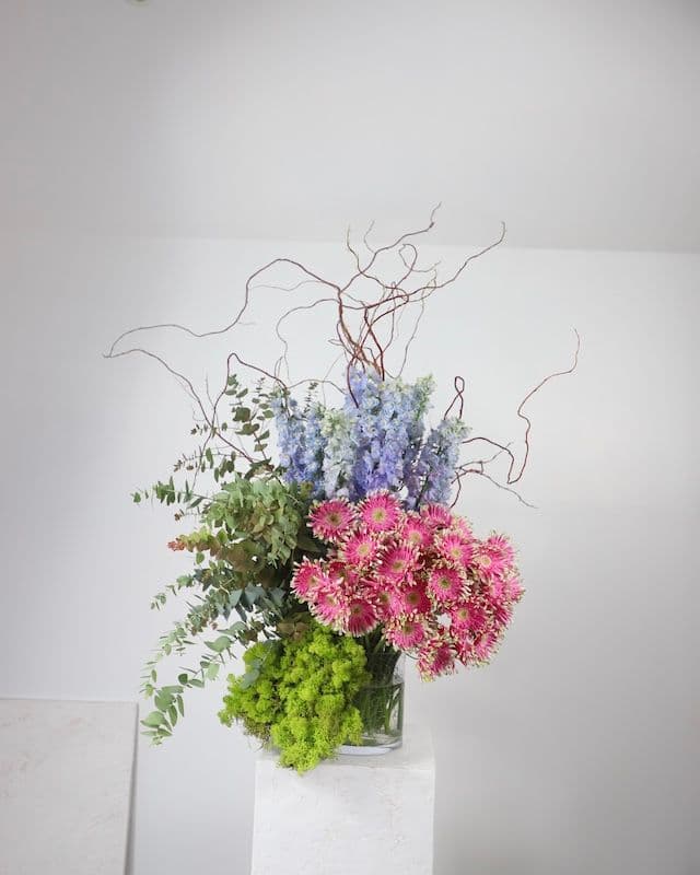 Composition florale moderne et excentrique avec gerberas Pasta roses, delphinium bleu, eucalyptus