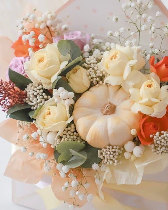 Enveloppe avec des fleurs et une mini citrouille.