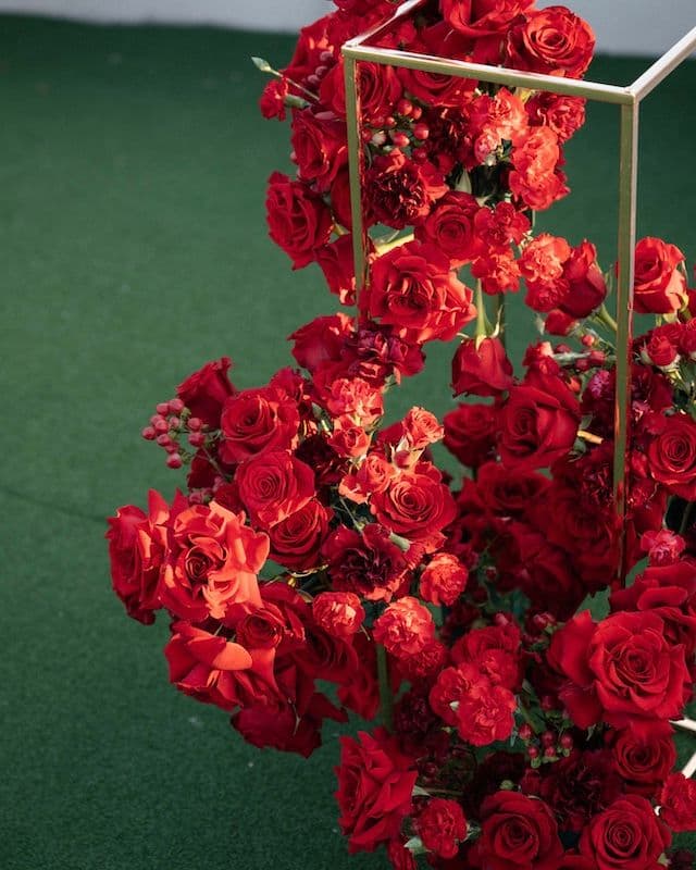 Set de mariage – Deux compositions sur structures métalliques + bouquet de mariée & boutonnière – Roses rouges, œillets & fleurs variées