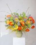 Composition florale avec coquelicots multicolores, genêt jaune et delphinium bleu