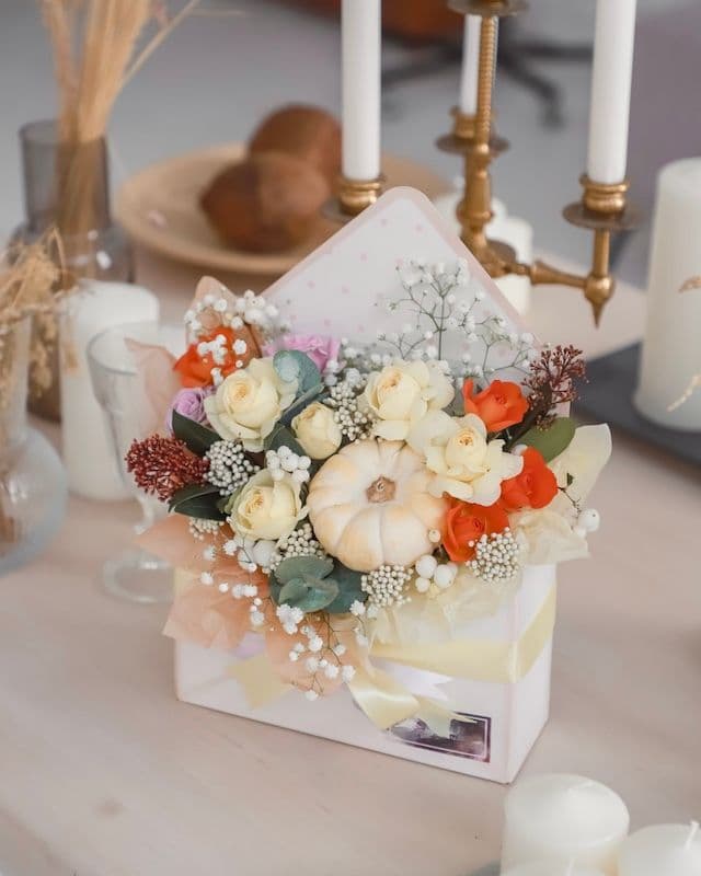 Enveloppe avec des fleurs et une mini citrouille.