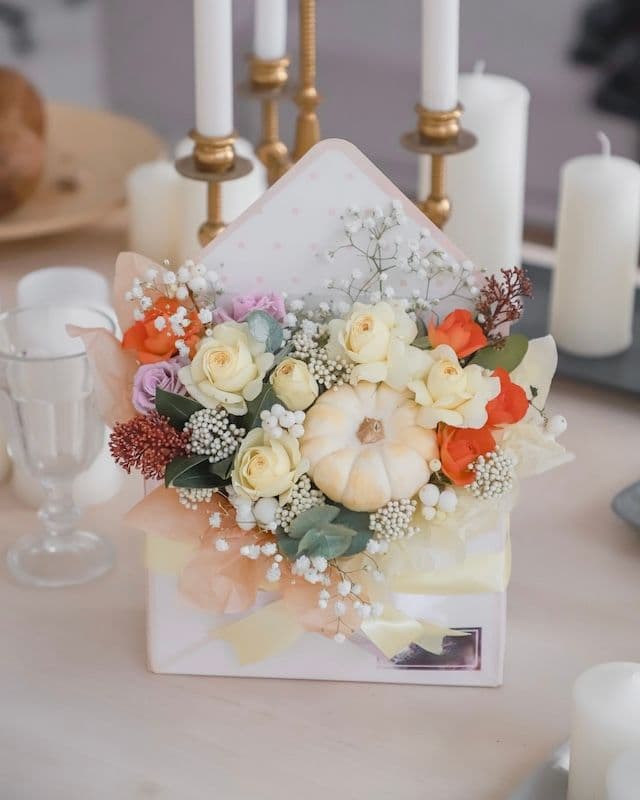 Enveloppe avec des fleurs et une mini citrouille.