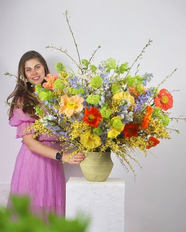 Composition florale avec coquelicots multicolores, genêt jaune et delphinium bleu