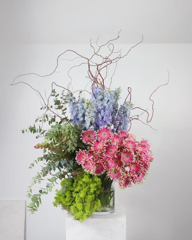 Composition florale moderne et excentrique avec gerberas Pasta roses, delphinium bleu, eucalyptus